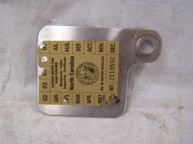 THIS IS A USED STAINLESS STEEL INSPECTION STICKER MOUNT PLATE FROM A 